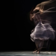 foto en larga exposición de una mujer bailando en un escenario oscuro